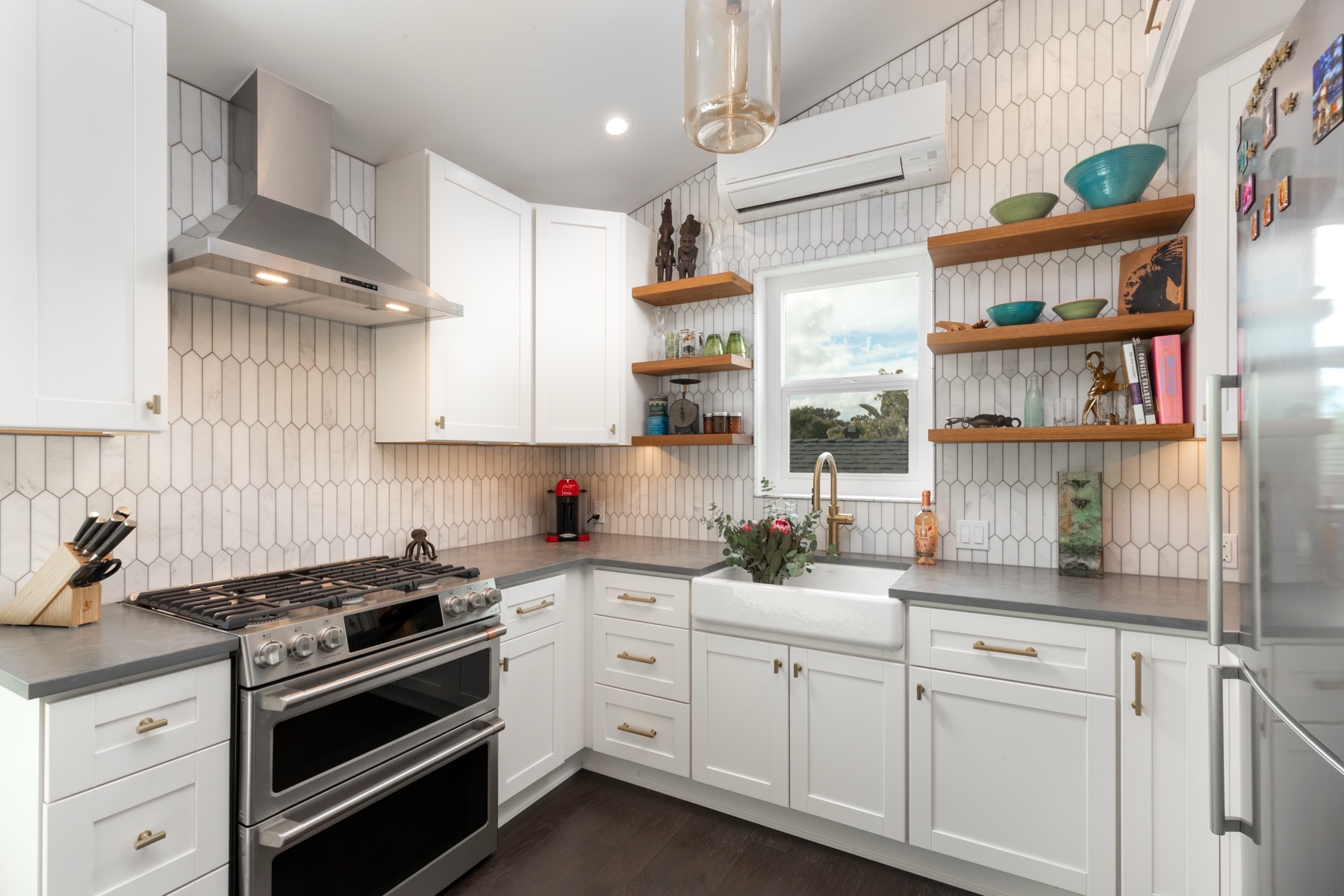 Kitchen remodel with white picket tile backsplash, open shelving, and professional double oven range